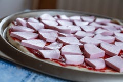 Pizzy ciasto mażący z ketchupem i z plasterkami kiełbasa jako tło fotografia stock Pizzy ciasto mażący z ketchupem i z plasterkami kiełbasa jako tło fotografia stock
