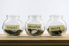 Pièces de monnaie dans le récipient en verre avec le voyage, labels d'économie et d'éducation images stock Pièces de monnaie dans le récipient en verre avec le voyage, labels d'économie et d'éducation images stock