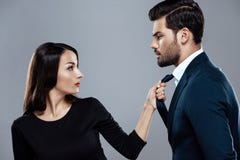 Piękna brunetki kobieta w czerni sukni trzyma eleganckiego mężczyzna krawatem zdjęcie royalty free Piękna brunetki kobieta w czerni sukni trzyma eleganckiego mężczyzna krawatem zdjęcie royalty free