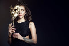 Piękna dama z zamkniętymi oczami chuje połówkę jej twarz za Wenecką maską Zdjęcia Stock Piękna dama z zamkniętymi oczami chuje połówkę jej twarz za Wenecką maską Zdjęcia Stock