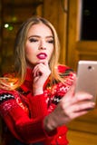Piękna dziewczyna bierze selfie z świątecznymi światłami obrazy royalty free Piękna dziewczyna bierze selfie z świątecznymi światłami obrazy royalty free