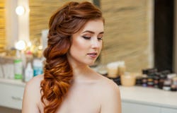 Piękna dziewczyna, z długi, miedzianowłosy kosmatym, Fryzjer wyplata Francuskiego warkocz, zakończenie w piękno salonie obraz stock Piękna dziewczyna, z długi, miedzianowłosy kosmatym, Fryzjer wyplata Francuskiego warkocz, zakończenie w piękno salonie obraz stock