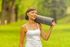 Piękna kobieta z joga matą outdoors Obraz Stock Piękna kobieta z joga matą outdoors Obraz Stock