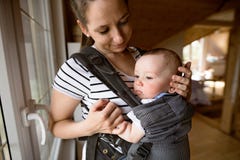 Piękna matka z jej ślicznym małym synem w dziecko przewoźniku obraz stock Piękna matka z jej ślicznym małym synem w dziecko przewoźniku obraz stock