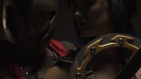 Piękna para, Romański legionnaire i amazonki kobiety stojak na szarym tle, zakończenie up zbiory Piękna para, Romański legionnaire i amazonki kobiety stojak na szarym tle, zakończenie up zbiory
