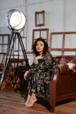 Piękny azjaty modela obsiadanie w brązu krześle w kwiat sukni zdjęcia stock Piękny azjaty modela obsiadanie w brązu krześle w kwiat sukni zdjęcia stock