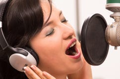 Piękny młoda dziewczyna śpiew w muzycznym studiu obraz royalty free Piękny młoda dziewczyna śpiew w muzycznym studiu obraz royalty free