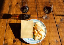 Placa com queijo e vinho tinto do regiano do parmigiana imagem de stock royalty free Placa com queijo e vinho tinto do regiano do parmigiana imagem de stock royalty free