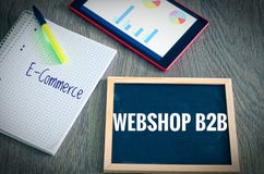 Placa con la inscripción Webshop B2B interempresarial y comercio electrónico con los gráficos y estadísticas de una tableta y blo imagenes de archivo Placa con la inscripción Webshop B2B interempresarial y comercio electrónico con los gráficos y estadísticas de una tableta y blo imagenes de archivo