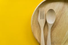 Placez de la fourchette, de la cuill?re et du bois de plat avec le fond jaune images stock Placez de la fourchette, de la cuill?re et du bois de plat avec le fond jaune images stock