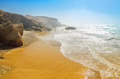 Plage d'océan en été sous le ciel bleu Vagues enroulant sur le rivage rocheux Images stock Plage d'océan en été sous le ciel bleu Vagues enroulant sur le rivage rocheux Images stock