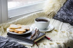 Plaid, coussin, biscuits et tasse de café sur le filon-couche de fenêtre images stock Plaid, coussin, biscuits et tasse de café sur le filon-couche de fenêtre images stock