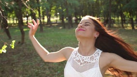 Plan rapproché d'une fille heureuse avec les cheveux débordants marchant en parc d'été au coucher du soleil banque de vidéos Plan rapproché d'une fille heureuse avec les cheveux débordants marchant en parc d'été au coucher du soleil banque de vidéos