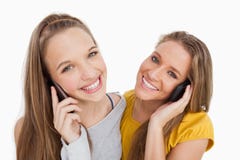 Plan rapproché de deux jeunes femmes souriant au téléphone image stock Plan rapproché de deux jeunes femmes souriant au téléphone image stock