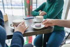 Plan rapproché de deux mains de femmes avec des tasses de café et de macarons de plat dans la main de l'homme sur le dessus de ta photos libres de droits Plan rapproché de deux mains de femmes avec des tasses de café et de macarons de plat dans la main de l'homme sur le dessus de ta photos libres de droits