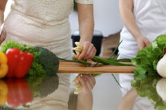 Plan rapproché des mains humaines faisant cuire dans une cuisine Amis ayant l'amusement tout en préparant la salade fraîche Végét Photographie stock libre de droits