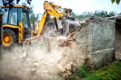 Planierraupe, die konkrete Backsteinmauern des kleinen Gebäudes demoliert Stockfoto Planierraupe, die konkrete Backsteinmauern des kleinen Gebäudes demoliert Stockfoto