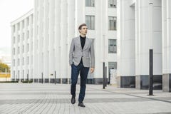 Plano distante do homem de negócio novo que vai ao lado do centro de negócios moderno fotografia de stock royalty free Plano distante do homem de negócio novo que vai ao lado do centro de negócios moderno fotografia de stock royalty free