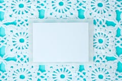 Plano, puesto, una hoja de papel para el texto en un fondo azul con el cordón blanco hecho a ganchillo del vintage, tema del invi foto de archivo Plano, puesto, una hoja de papel para el texto en un fondo azul con el cordón blanco hecho a ganchillo del vintage, tema del invi foto de archivo