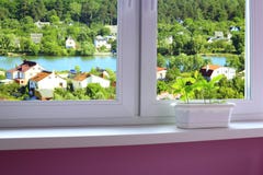 Plantule delle querce nel fiore-vaso e della vista alla città verde con il lago immagini stock libere da diritti Plantule delle querce nel fiore-vaso e della vista alla città verde con il lago immagini stock libere da diritti