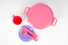 Plastic children`s dishes pink and lilac colour on a white background isolated royalty free stock photography Plastic children`s dishes pink and lilac colour on a white background isolated royalty free stock photography