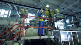Plastik-produzierende Einheit mit einer männlichen Arbeitskraft, die auf einer Plattform steht stock footage Plastik-produzierende Einheit mit einer männlichen Arbeitskraft, die auf einer Plattform steht stock footage