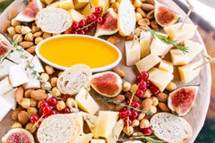 Plat de fromage Préparation délicieuse de fromage avec des croûtons de baguette, groseille rouge, figues douces, amande, miel sur photo libre de droits Plat de fromage Préparation délicieuse de fromage avec des croûtons de baguette, groseille rouge, figues douces, amande, miel sur photo libre de droits