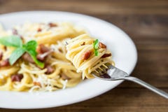 Plate of Pasta Carbonara and Spaghetti with bacon and parmesan cheese on a fork on old wooden table stock photos Plate of Pasta Carbonara and Spaghetti with bacon and parmesan cheese on a fork on old wooden table stock photos