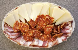 Plate with sliced homemade sheep cheese, ham, sausages and prosciutto. Domestic and organic food concept stock photos Plate with sliced homemade sheep cheese, ham, sausages and prosciutto. Domestic and organic food concept stock photos
