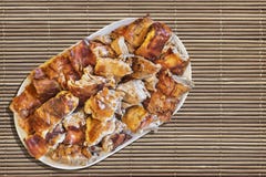 Plateful зажаренных в духовке вертелом кусков свинины установленных на поверхность Grunge циновки места соломы Стоковые Фото Plateful зажаренных в духовке вертелом кусков свинины установленных на поверхность Grunge циновки места соломы Стоковые Фото