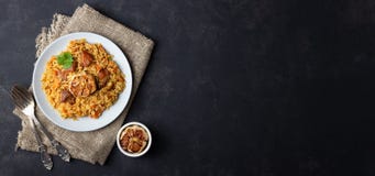 Plato asi?tico tradicional - pilaf del arroz, de verduras y de la carne en una placa en fondo negro imagenes de archivo Plato asi?tico tradicional - pilaf del arroz, de verduras y de la carne en una placa en fondo negro imagenes de archivo