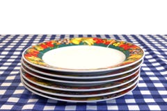 Plats de porcelaine dans la pile sur le Tableau de pique-nique d'isolement sur le blanc Photo libre de droits Plats de porcelaine dans la pile sur le Tableau de pique-nique d'isolement sur le blanc Photo libre de droits