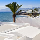 Playa del Carmen, Lanzarote, Canary Islands, Spain. A view of some whitewashed houses and the coastline of Playa del Carmen, in Lanzarote, Canary Islands, Spain royalty free stock photography Playa del Carmen, Lanzarote, Canary Islands, Spain. A view of some whitewashed houses and the coastline of Playa del Carmen, in Lanzarote, Canary Islands, Spain royalty free stock photography