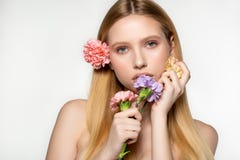 Playful and sexy portrait of pretty cheerful woman with spring flowers near her face, looking at the camera, isolated on royalty free stock image Playful and sexy portrait of pretty cheerful woman with spring flowers near her face, looking at the camera, isolated on royalty free stock image
