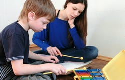 Playing music instrument. Boy repeats for the teacher playing the notes on the xylophone. royalty free stock photos Playing music instrument. Boy repeats for the teacher playing the notes on the xylophone. royalty free stock photos