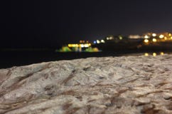 Plaża przy nocą z miastem zaświeca w odległości zdjęcie stock Plaża przy nocą z miastem zaświeca w odległości zdjęcie stock
