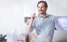 Pleasant smiling adult man drinking coffee at home Royalty Free Stock Images Pleasant smiling adult man drinking coffee at home Royalty Free Stock Images