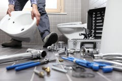 Plumber at work in a bathroom, plumbing repair service, assemble stock image Plumber at work in a bathroom, plumbing repair service, assemble stock image