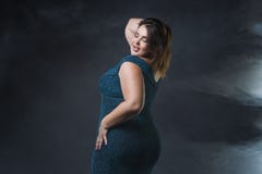 Plus formatmodemodell i grön aftonklänning fet kvinna på svart bakgrund, stående med yrkesmässig makeup Fotografering för Bildbyråer Plus formatmodemodell i grön aftonklänning fet kvinna på svart bakgrund, stående med yrkesmässig makeup Fotografering för Bildbyråer