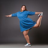 Plus size model in denim dress, fat woman on gray background, overweight female body royalty free stock images Plus size model in denim dress, fat woman on gray background, overweight female body royalty free stock images