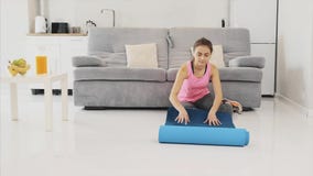 Po pracować w domu w żywym pokoju zamyka w górę młodej pięknej kobiety ubierającej lub maty w błękita jogging sprawności fizyczne zbiory wideo Po pracować w domu w żywym pokoju zamyka w górę młodej pięknej kobiety ubierającej lub maty w błękita jogging sprawności fizyczne zbiory wideo