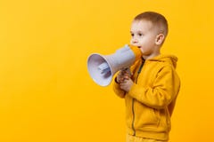 Poco ragazzo del bambino di divertimento 3-4 anni in vestiti gialli tenere, parlante in megafono elettronico isolato sulla parete immagine stock Poco ragazzo del bambino di divertimento 3-4 anni in vestiti gialli tenere, parlante in megafono elettronico isolato sulla parete immagine stock