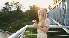 podmuchowych bąbli mydlana kobieta Boczny widok dmucha mydlanych bąble ładna kobieta podczas gdy stojący na zwyczajnym moscie zdjęcie wideo podmuchowych bąbli mydlana kobieta Boczny widok dmucha mydlanych bąble ładna kobieta podczas gdy stojący na zwyczajnym moscie zdjęcie wideo