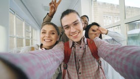 Point of view of four positive cheerful attractive multi-ethnic friends talking selfie photos holding smartphone and stock footage Point of view of four positive cheerful attractive multi-ethnic friends talking selfie photos holding smartphone and stock footage