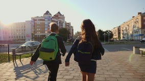 Pojke- och flickaspring med ryggsäckar som är sena lager videofilmer Pojke- och flickaspring med ryggsäckar som är sena lager videofilmer