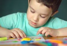 Pojke som spelar med färglekdeg Arkivbild Pojke som spelar med färglekdeg Arkivbild