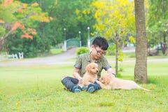 Pojkesammanträde och samtal med hans hund parkerar in arkivfoto Pojkesammanträde och samtal med hans hund parkerar in arkivfoto