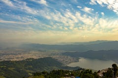 Pokhara stad under en blå himmel med vita moln i en dal för dimmigt berg på sjöPhewa den flyg- sikten fotografering för bildbyråer Pokhara stad under en blå himmel med vita moln i en dal för dimmigt berg på sjöPhewa den flyg- sikten fotografering för bildbyråer