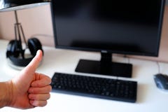 Polegares acima, um sinal do elogio Local de trabalho equipado para o trabalho no computador Foco seletivo foto de stock Polegares acima, um sinal do elogio Local de trabalho equipado para o trabalho no computador Foco seletivo foto de stock