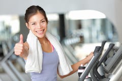 Polegares felizes da mulher da aptidão acima no gym